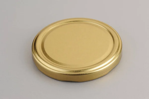 Screw cap for glass jars. For canning, canned food. Golden cap on gray background — Stock Photo, Image