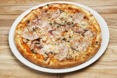 Ahşap bir arka plan üzerinde peynir, mantar ve domates ile lezzetli pizza
