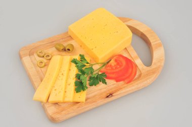 Peynir dilimi, maydanoz, domates dilimi, kesme tahtası üzerinde gri arka plan kesim izole