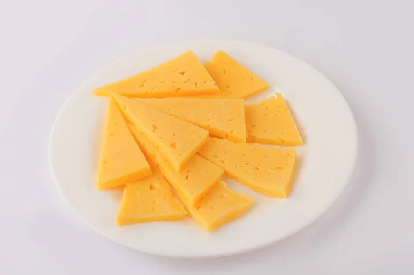 Rebanada de queso aislado sobre fondo gris recorte en un plato — Foto de Stock