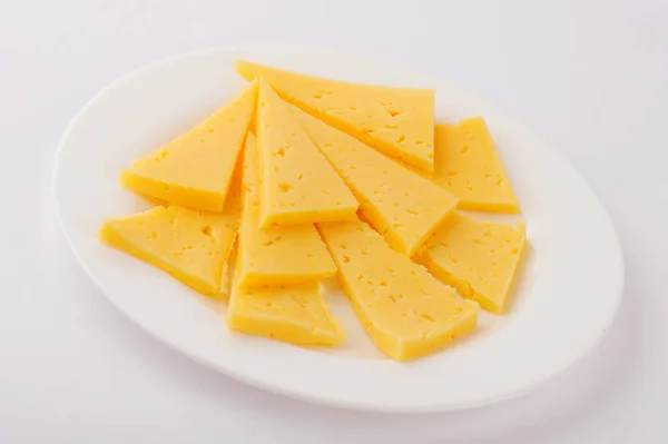 Rebanada de queso aislado sobre fondo gris recorte en un plato —  Fotos de Stock