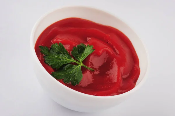 Ένα μικρό μπολ με κόκκινη σάλτσα ντομάτας και μαϊντανό απομονωμένο σε λευκό φόντο — Φωτογραφία Αρχείου