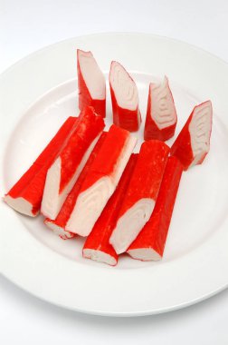 Yengeç beyaz bir arka plan üzerinde bir tabak üzerinde sopa