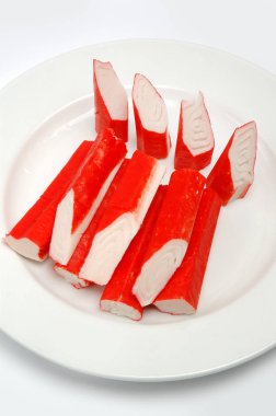 Yengeç beyaz bir arka plan üzerinde bir tabak üzerinde sopa