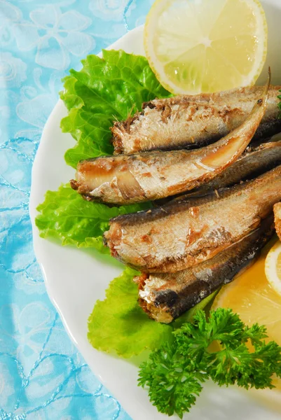 Serpenyőben sült fűszeres sprats citrommal, salátával, tányéron — Stock Fotó