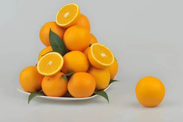 Fresh oranges on the plate isolated on gray background — Stock Photo, Image