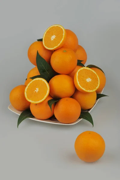회색 배경에 고립 된 접시에 신선한 오렌지 — 스톡 사진