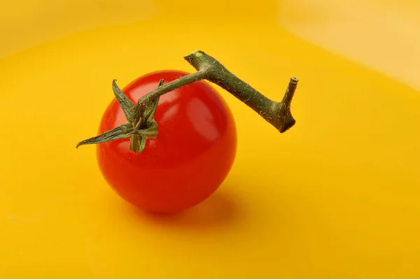 노란 배경에 줄기가 있는 신선한 토마토 — 스톡 사진