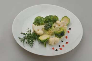 Plaka gri arka plan üzerinde farklı yeşil sebzeler