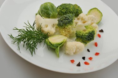 Plaka gri arka plan üzerinde farklı yeşil sebzeler