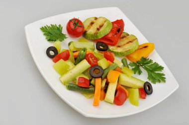 Plaka gri arka plan üzerinde farklı yeşil sebzeler