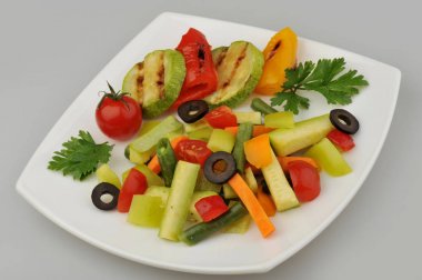 Plaka gri arka plan üzerinde farklı yeşil sebzeler