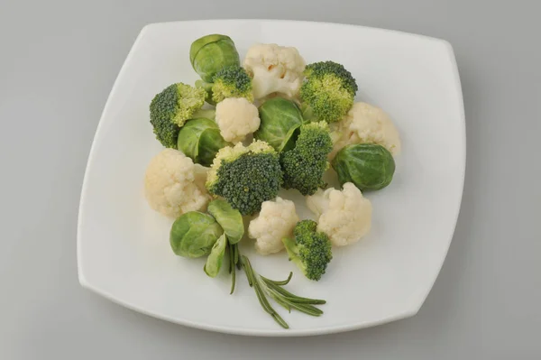 Verschiedene grüne Gemüse auf dem Teller grauen Hintergrund — Stockfoto