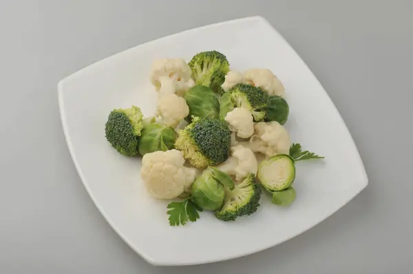 Различные зеленые овощи на серый фон тарелки — стоковое фото