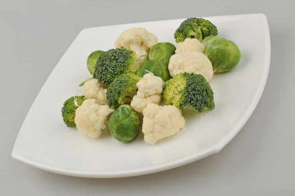 Verschiedene grüne Gemüse auf dem Teller grauen Hintergrund — Stockfoto