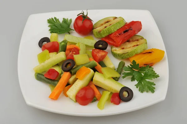 Різні зелені овочі на тарілці сірий фон — стокове фото