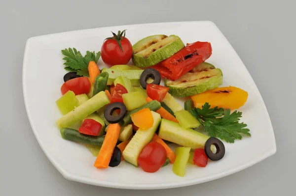 Diferentes verduras verdes en el fondo gris plato — Foto de Stock