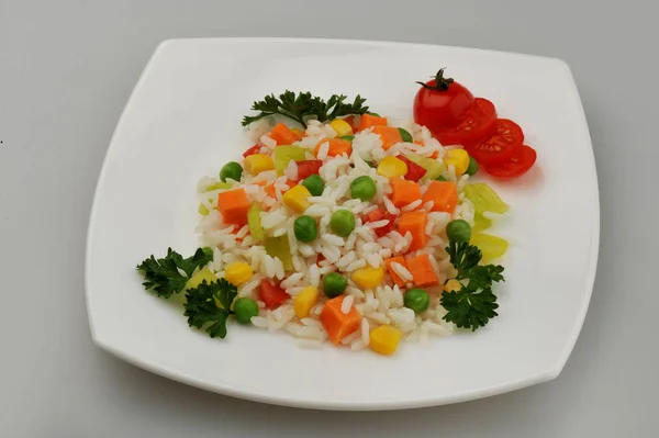 Тарілка рису з овочами на сірому фоні — стокове фото