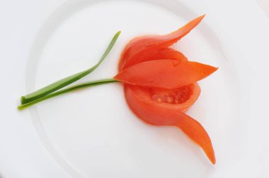 Beyaz tabak çiçek kesilmiş domates süslenmiş
