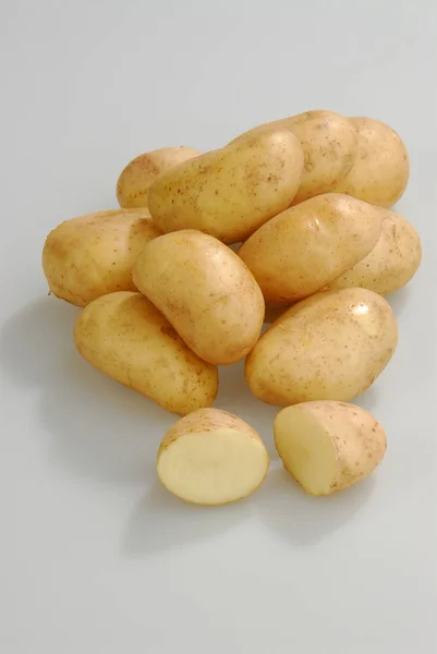 Πολλές πρώτες πατάτες σε ένα γκρι απομονωμένο φόντο — Φωτογραφία Αρχείου