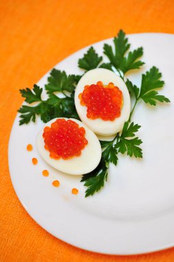 Yumurta füme somon ve maydanoz dekor ile bir tabak, turuncu arka plan ile doldurulmuş