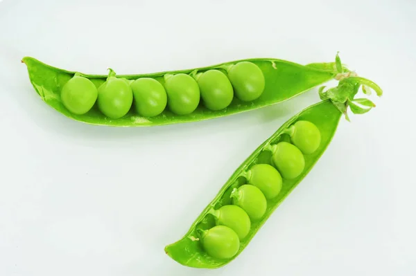 Čerstvý zelený hrášek izolovaný na šedém pozadí — Stock fotografie