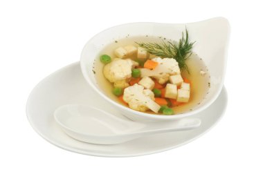 Beyaz izole arka planda karnabahar, patates, bezelye, havuç ve dereotu ile sebze çorbası