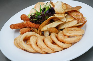 Tavuk nuggets, patates kızartması ve sos. Kızarmış nuggets ve fesleğen meşe marul ile patates