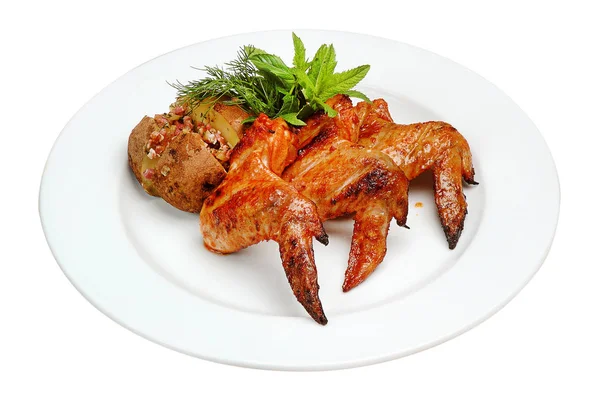 Tavuk kanatları, patates dolması, nane, dereotu, beyaz izole arka plan üzerinde bir tabak üzerinde