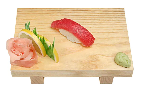 Nigiri avec thon sur un support en bois, wasabi et gingembre mariné. Sur fond blanc isolé — Photo