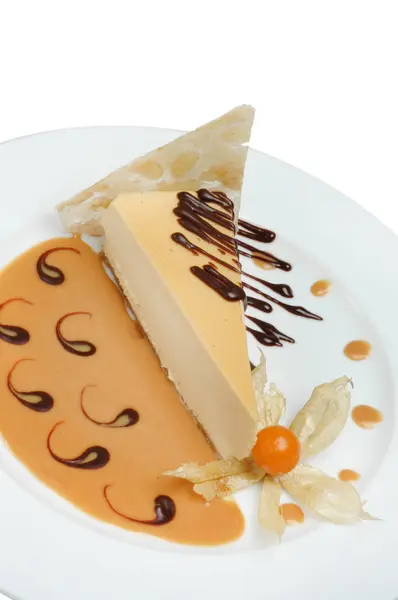 Un pedazo de pastel con leche condensada bellamente decorado en un plato sobre un fondo blanco — Foto de Stock