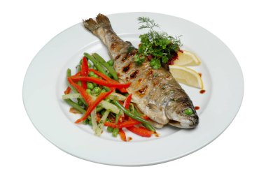 Beyaz izole arka plan üzerinde bir tabak üzerinde sebze ve limon dilimleri ile kızarmış balık