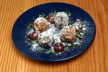 Ahşap arka planda mavi plaka üzerinde dekor ile et topları