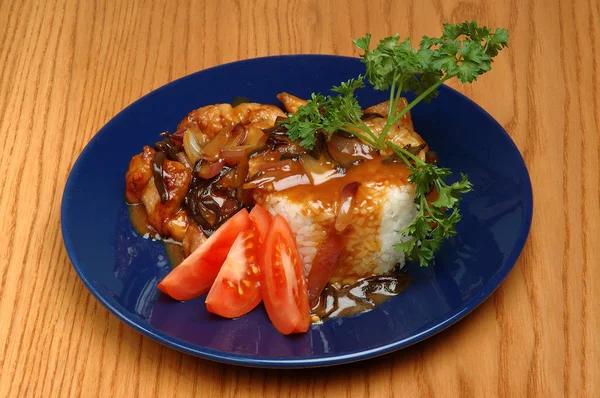 Mavi plaka üzerinde pirinç ve maydanoz ile deniz ürünleri tabağı