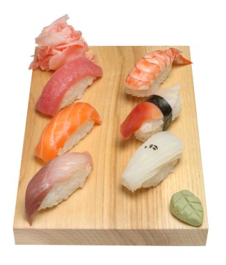 Nigiri ahşap bir stand, Wasabi ve salamura zencefil üzerinde ayarlayın. Beyaz izole arka planda