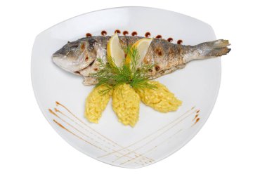 Beyaz izole arka planda bir plaka üzerinde pirinç ve limon dilimleri ile kızarmış balık