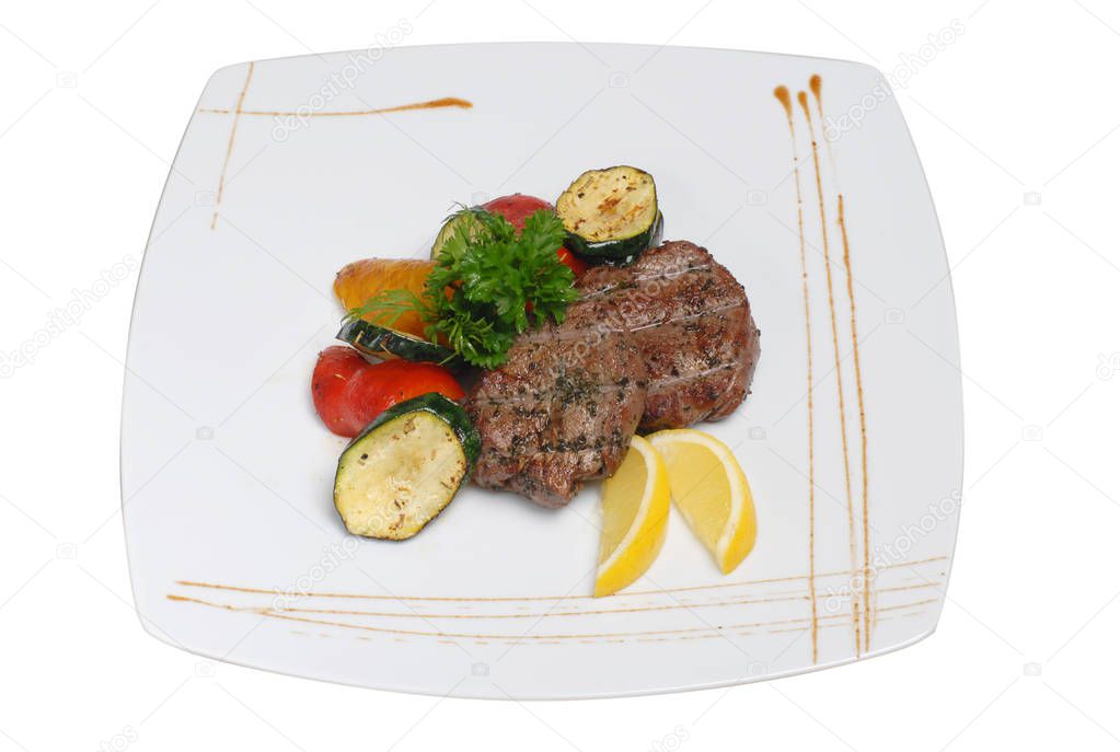 Grilled beef steaks and vegetables on a white isolated background