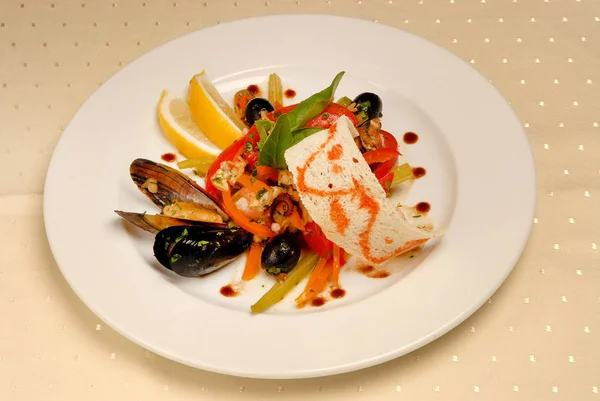 Salad dari sayuran dan makanan laut dengan zaitun dan lemon di piring persegi pada latar belakang putih terisolasi — Stok Foto