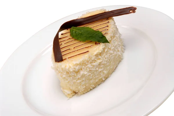 Scheibe leckerer Kokosnusskuchen auf einem Teller auf weißem Hintergrund — Stockfoto