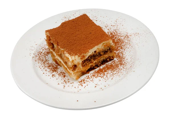 Rebanada de delicioso pastel en un plato blanco sobre fondo blanco aislado — Foto de Stock