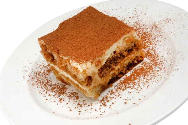 Rebanada de delicioso pastel en un plato blanco sobre fondo blanco aislado — Foto de Stock