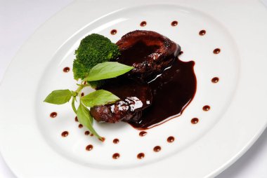 Yemeğin ortasında soya sosu ile beyaz tabakta lezzetli ızgara et uyluk, yukarıdan görünümü, yakın çekim