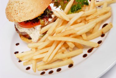 Beyaz izole arka plan üzerinde bir tabak üzerinde patates kızartması ve domates sosu ile Burger