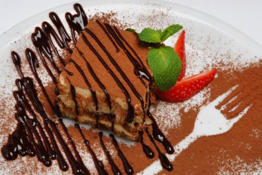 Gri bir arka plan üzerinde bir tabak üzerinde nane yaprakları ile Cheesecake