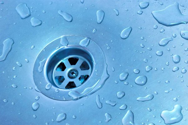 Водоотвод в раковине, водопроводное устройство. В доме вода вытекает из кухонного раковины через конструкцию дренажного устройства в канализацию
. 