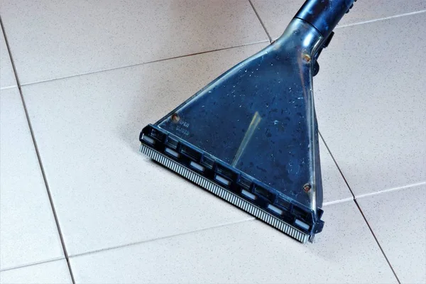 Cleaning the tiled floor surface with a washing vacuum cleaner.Maintaining safe hygiene cleanliness, removing dirt in industrial, commercial, home and for aesthetics.