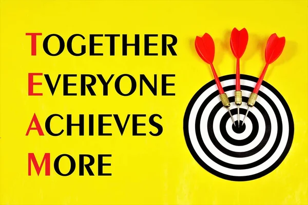 Teamwork-together everyone achieves more-lettering text on the background of a dartboard target. The concept of effective implementation of a specific goal in business.