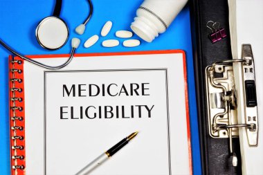 Medicare eligibility-text label in the office Registrar's folder. Insurance program, payment for medical care. clipart