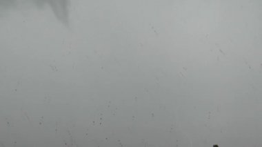 Gri bir gökyüzü ve yağmur damlaları penceresinde birden fazla yıldırım