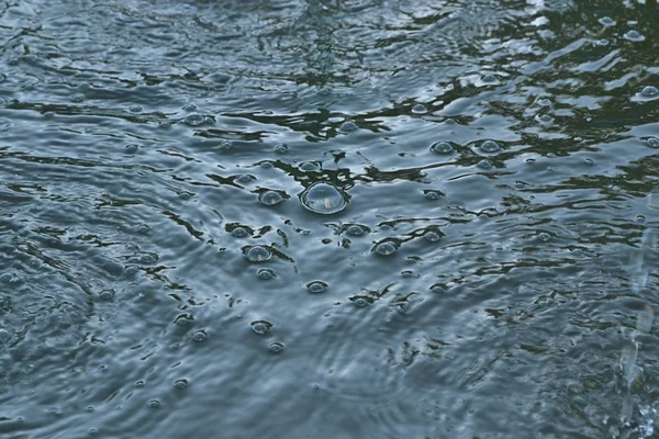 küçük kabarcıklar mavi su bir su birikintisi doku gökyüzünün yansıması ile
